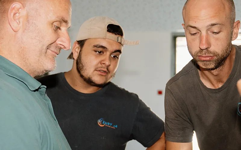 Trois techniciens Eury penchés sur un chantier